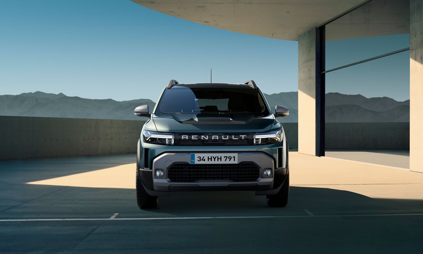 Front view of a Renault SUV parked in a modern concrete structure with mountains in the distance.
