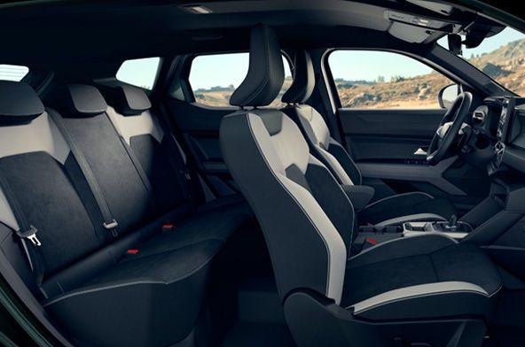 Interior of a modern car showing front bucket seats and a rear bench with black upholstery.