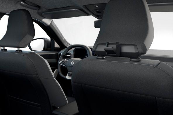 Rear-seat view of a car interior showing the two front seats, steering wheel with Renault emblem, and headrests in a dark fabric interior.