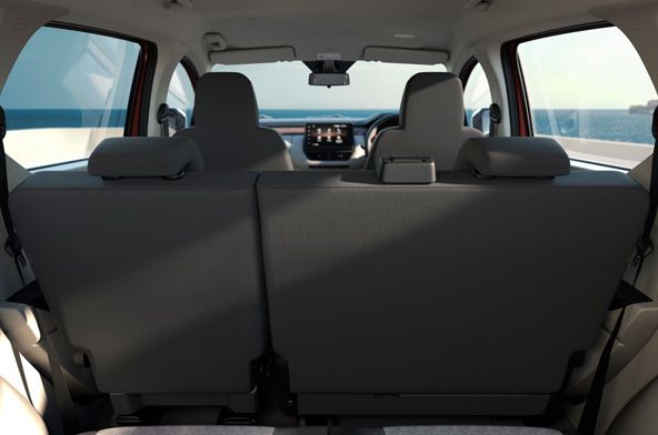Rear view of a car interior: back of the rear seats with headrests, front seats, and a center console/dashboard visible, ocean seen through the side windows.