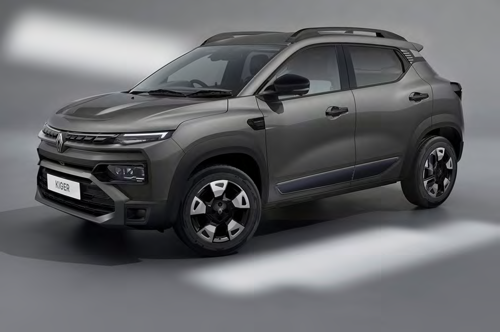 Grey Renault Kiger compact SUV shown in a three-quarter front view with roof rails and prominent front grille, plate reads KIGER.