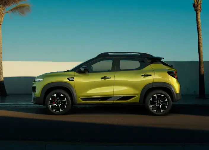 Lime-green crossover SUV parked on a sunny street beside a white wall and palm trees under a clear blue sky.