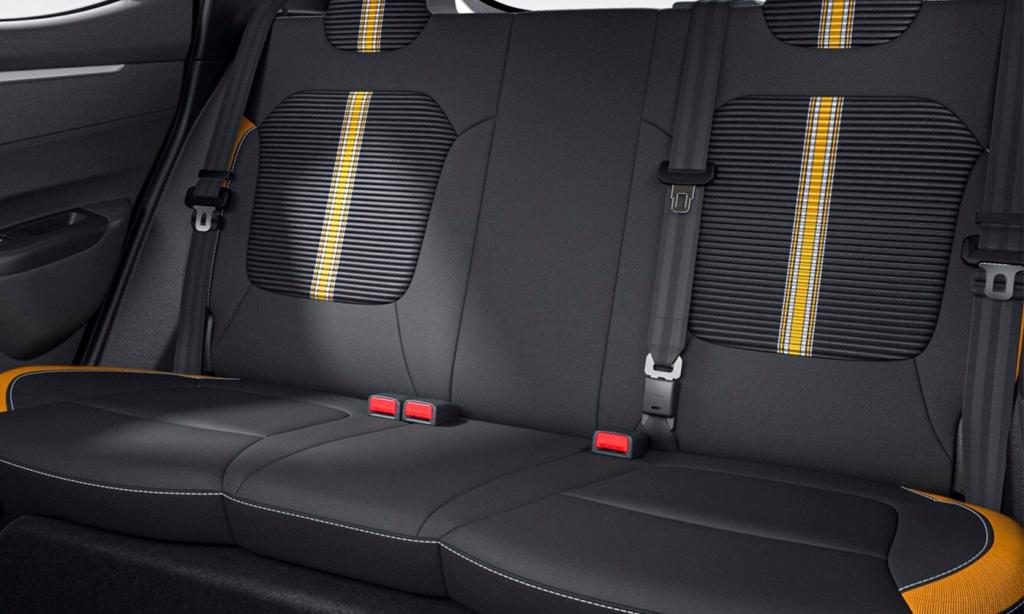 Rear car seats with black upholstery and yellow racing stripes, three seat belts and red latches.