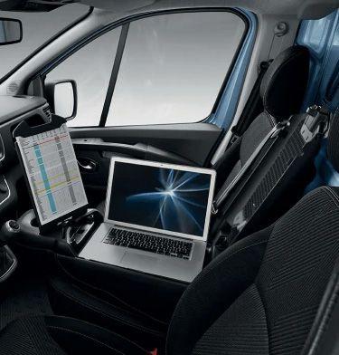 Laptop on the passenger seat with a tablet mounted near the dashboard, forming a mobile office in a van or SUV.