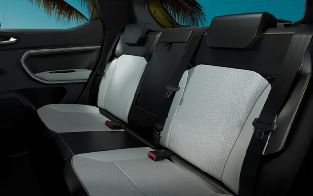 Rear passenger seats in a car with light gray upholstery and three-point seat belts visible across the bench-seat row.